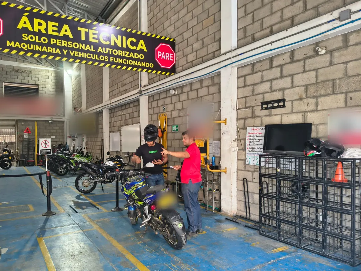 Atención a un cliente con su moto en el área técnica de TECNOMECÁNICA GIRÓN MOTOS, Girón