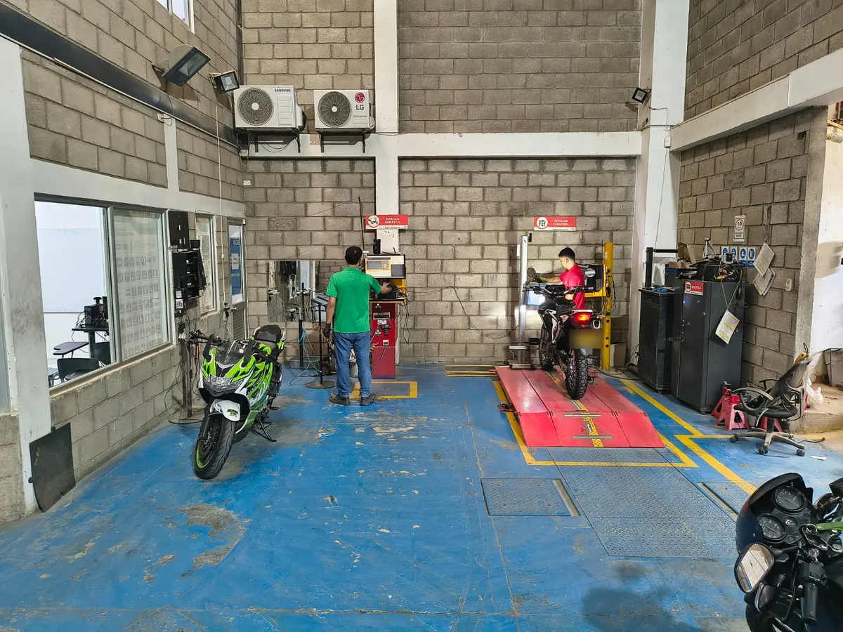 Técnicos de TECNOMECÁNICA GIRÓN MOTOS inspeccionando motos en las estaciones de revisión en Girón
